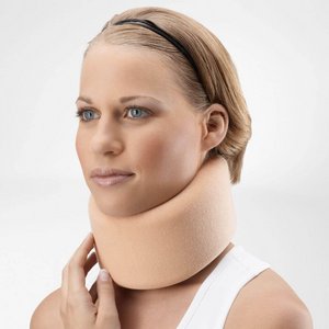 Porträt einer jungen Frau mit kurzem, blondem Haar und schwarzem Haarband. Sie trägt die beige Schaumstoff-Halskrause CerviLoc zur Stabilisierung der Halswirbelsäule