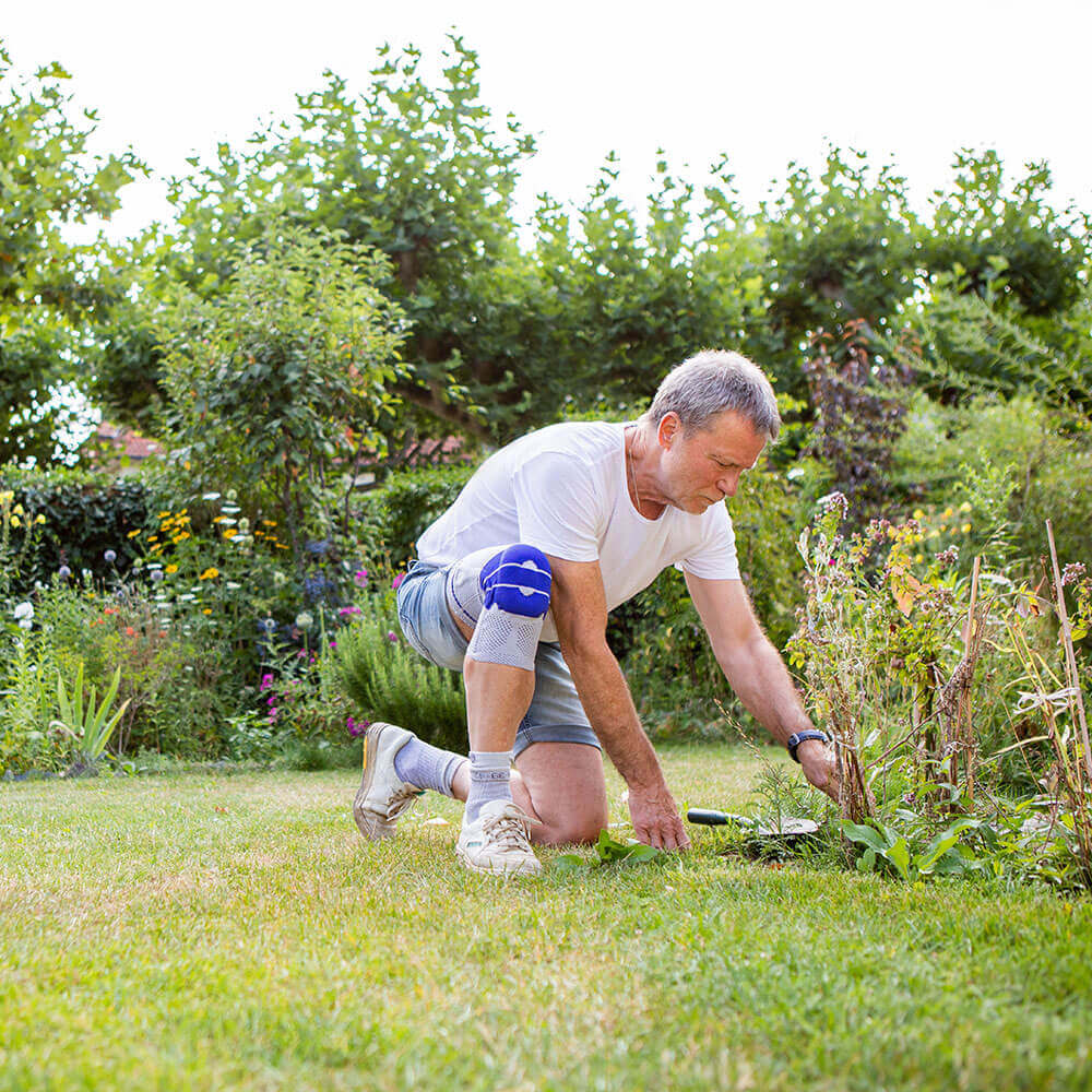 Dieter arbeitet in seinem Garten. Mit der Kniebandage GenuTrain von Bauerfeind werden seine Gelenkschmerzen bei der Arbeit zur Nebensache.